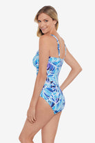 Woman turned left wearing a blue and white feather/leaf pattern one-piece swimsuit