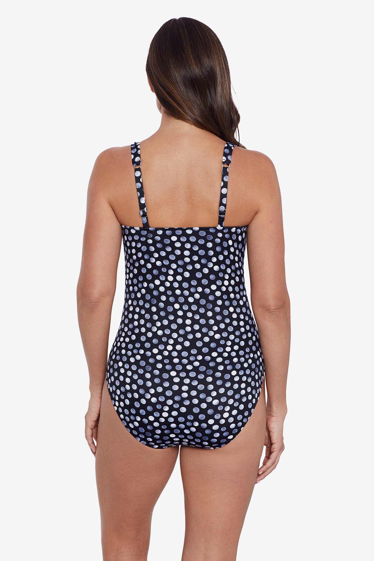 Woman faced away wearing grey and white polka dotted one-piece swimsuit