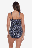 Woman faced away wearing grey and white polka dotted one-piece swimsuit