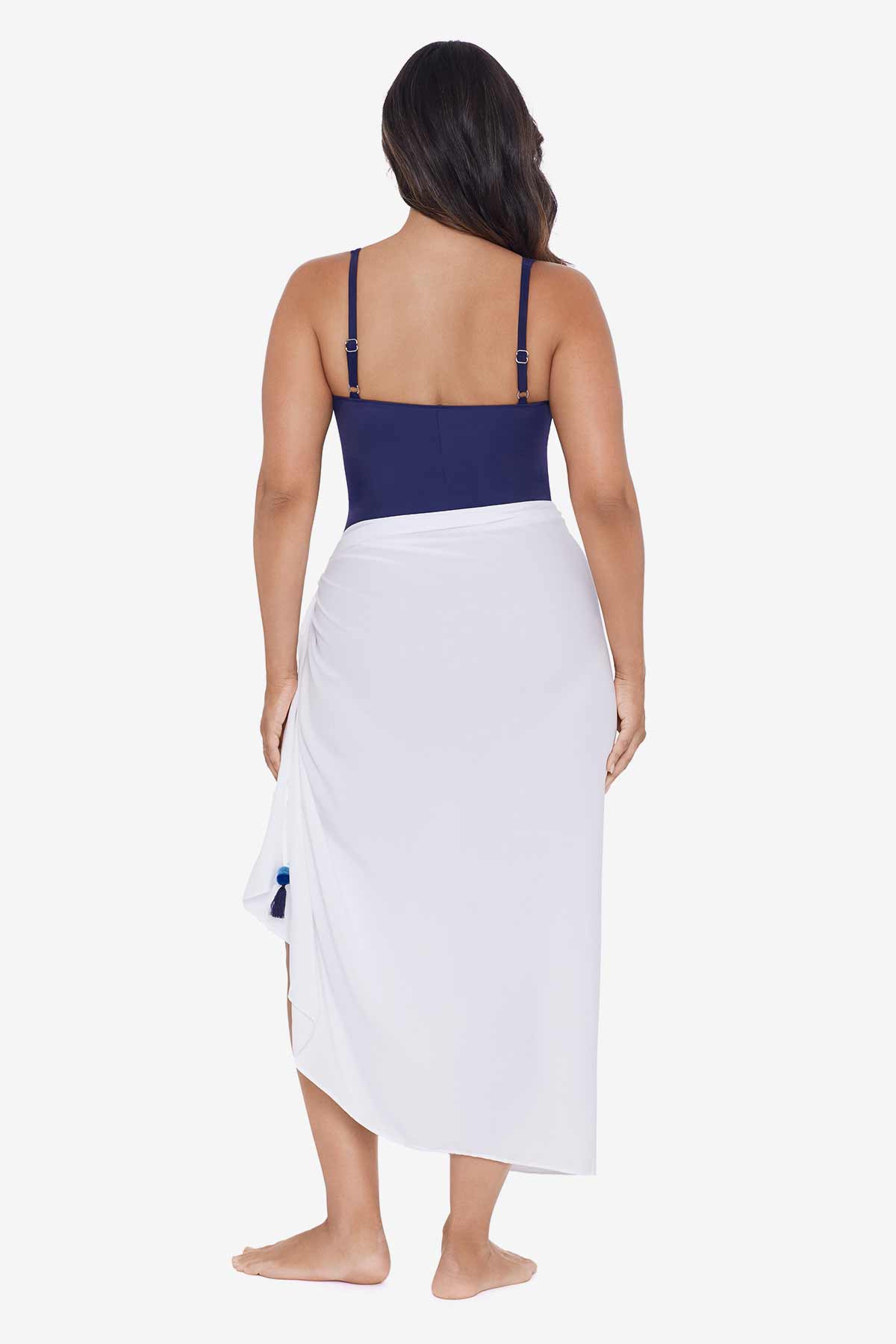 Woman faced away wearing a white swim wrap cover up with tassels