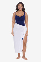 Woman wearing a white swim wrap cover up with tassels