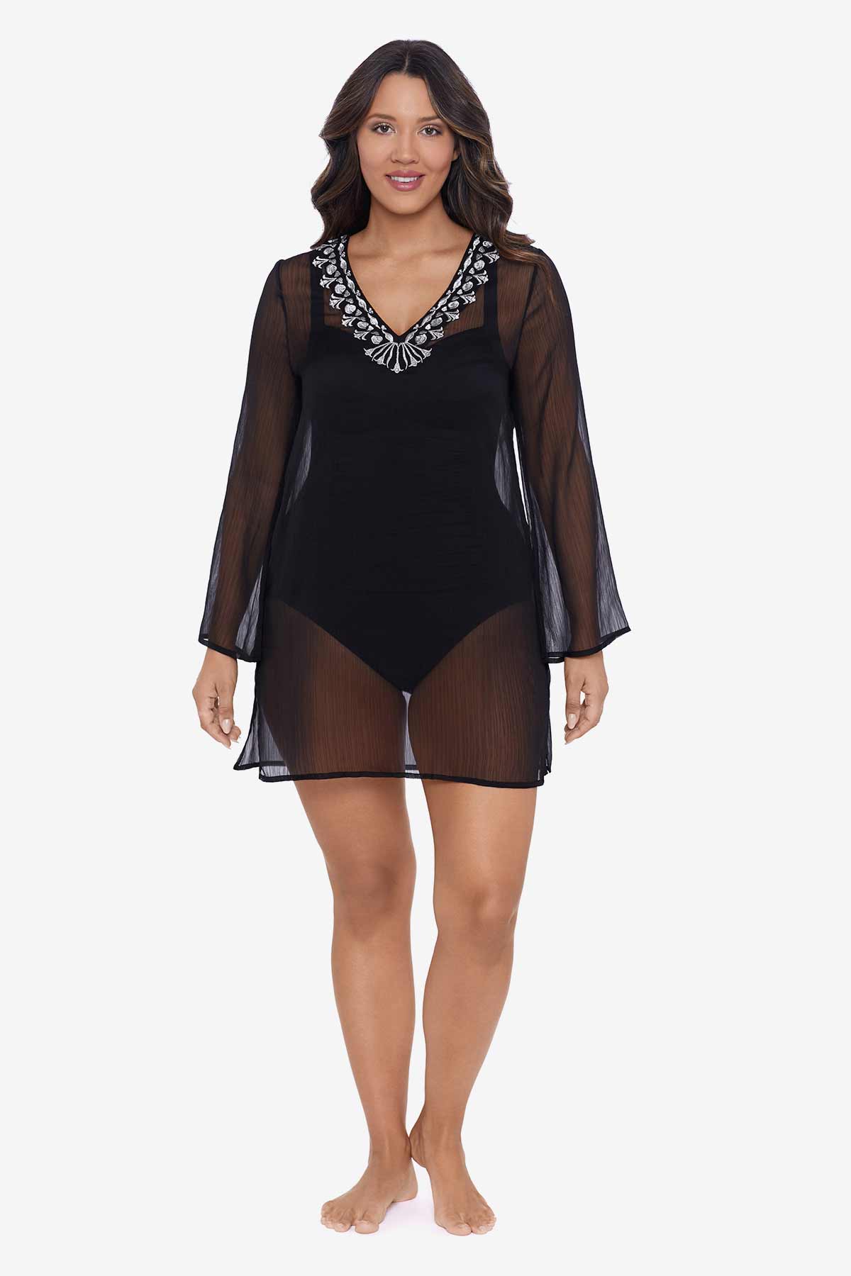 Woman wearing a black sheer swim cover up with silver trim on the neckline