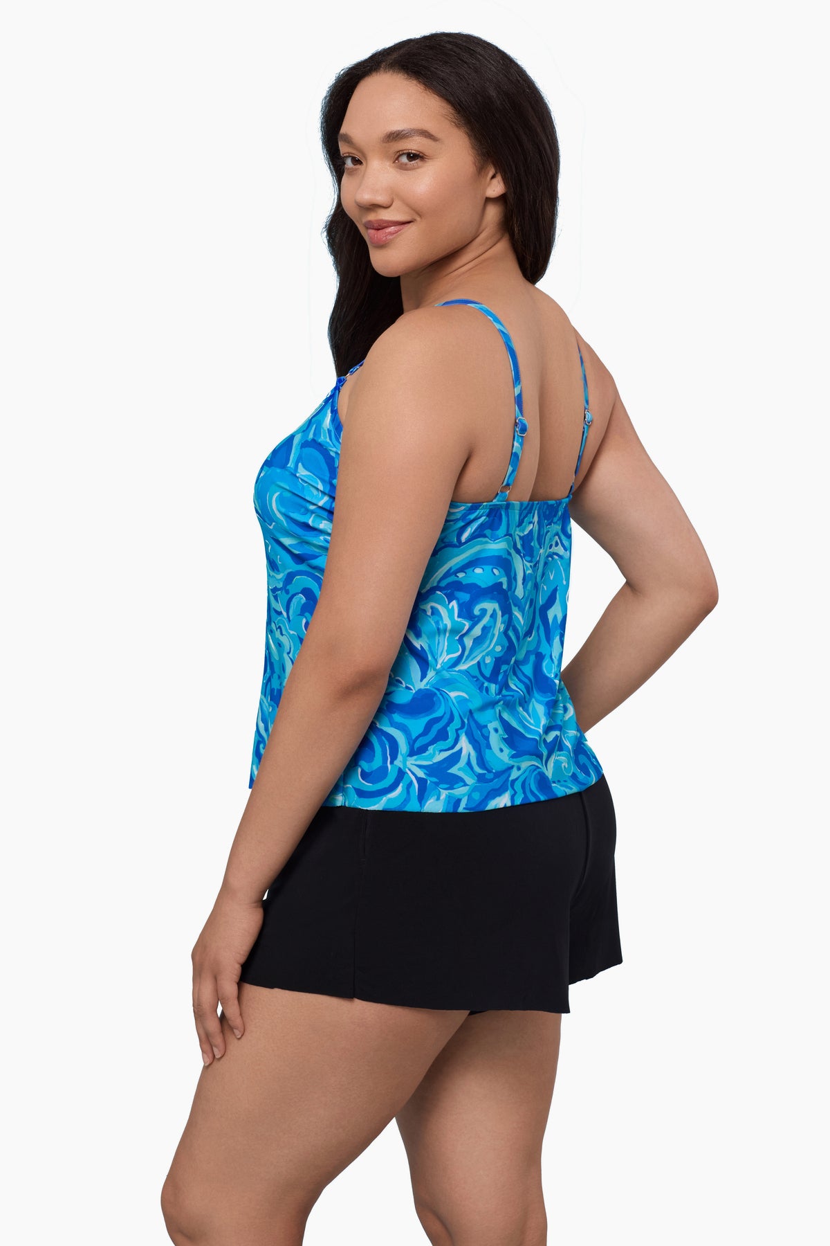 Woman turned left wearing a swim romper with an abstract blue print