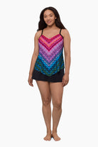 Woman wearing a tankini top with a multicolored geometric print