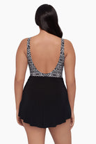 Woman turned away wearing a swim romper with a black and white print