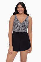 Woman wearing a swim romper with a black and white print