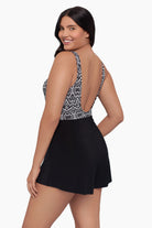 Woman turned left wearing a swim romper with a black and white print