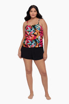 Woman wearing a swim romper with a bright multicolored floral pattern