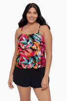 Woman wearing a swim romper with a bright multicolored floral pattern