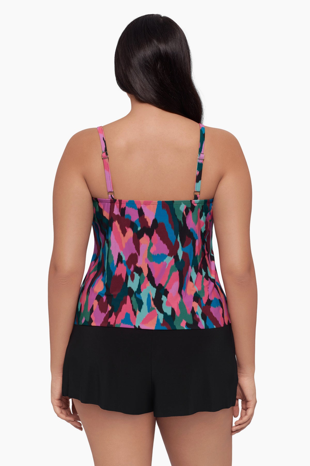 Woman turned away wearing a swim romper with a collage patchwork patter