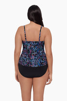 Woman turned away wearing a blue abstract tankini top with ruffles