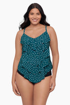 Woman wearing a tiered tankini top with a white polka dot pattern