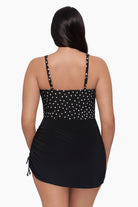 Woman turned away wearing a swim dress with black and white polka dots