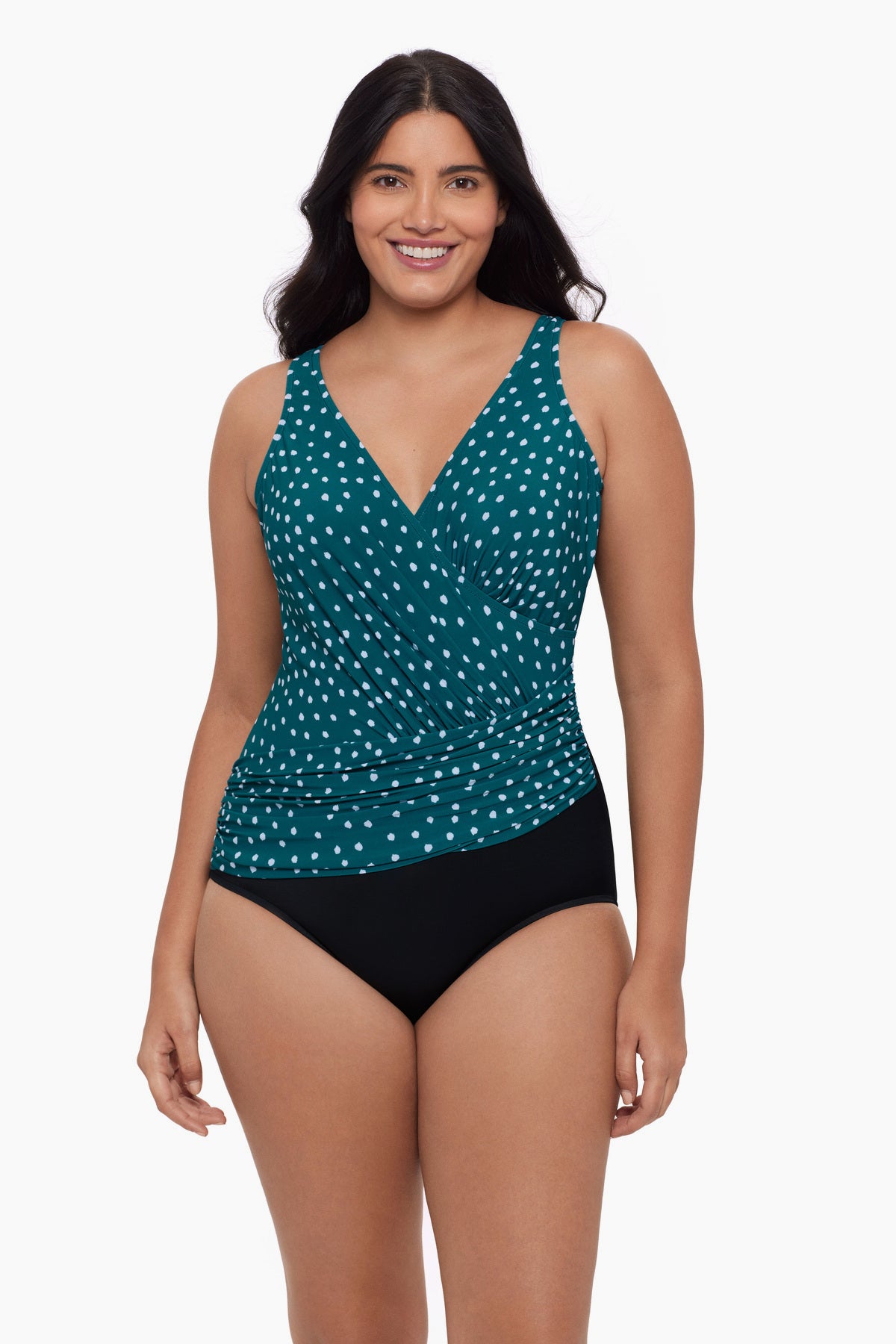 Woman wearing a one-piece swimsuit with a teal and white dot pattern