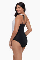 Woman turned left wearing a one-piece swimsuit with an asymmetrical cut