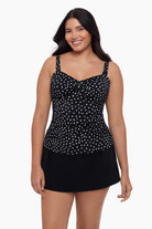 Woman wearing a tankini top with black and white polka dots 