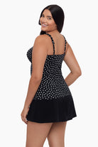 Woman turned left wearing a tankini top with black and white polka dots 