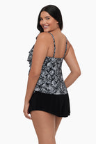 Woman turned left wearing a tiered tankini top with a black and white print