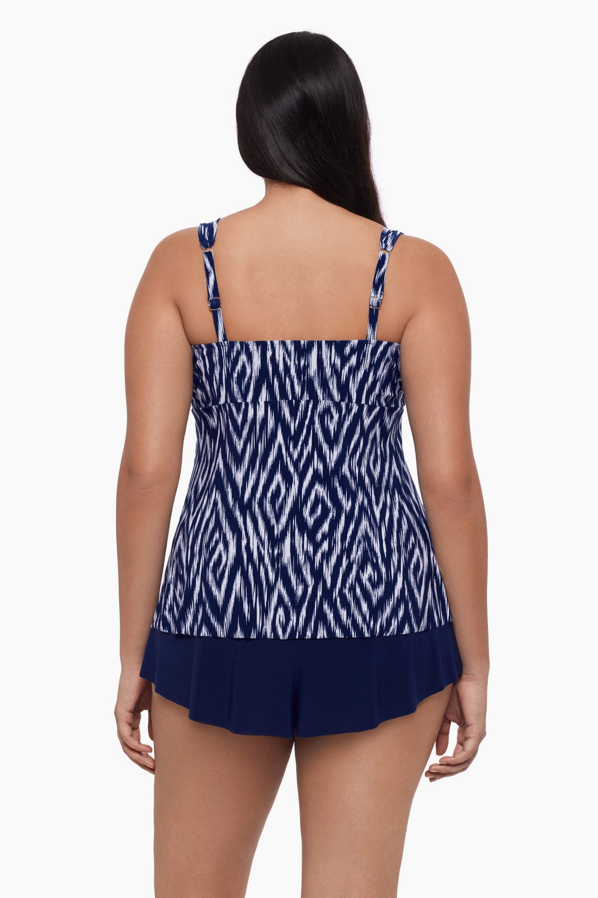 Woman turned away wearing a tankini top with an abstract blue and white print