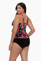 Woman turned left wearing a tiered tankini top with a red and pink floral pattern
