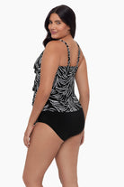 Woman turned left wearing a tankini top with a black and white dot pattern