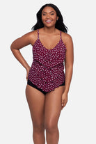 Woman wearing a maroon and white polka dot tankini top with ruffles