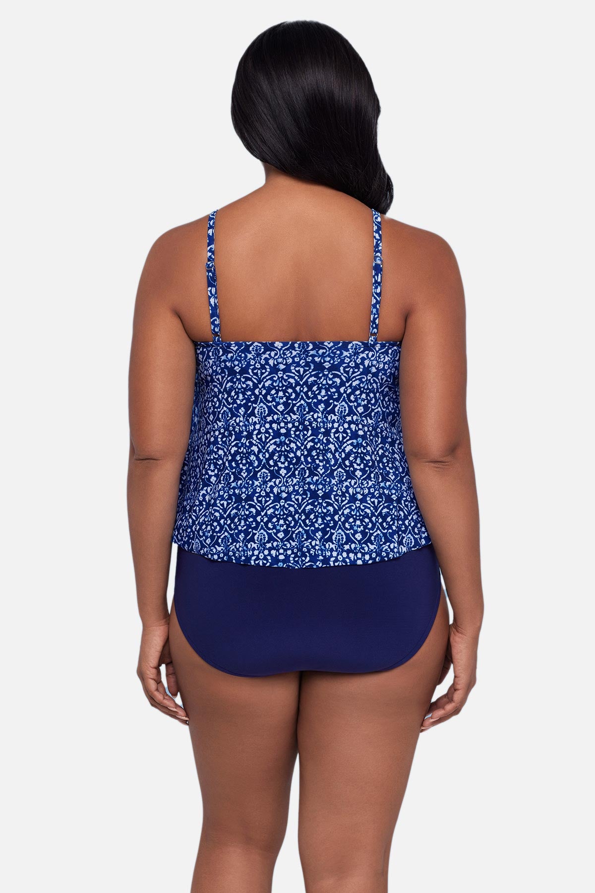 Woman turned away wearing a blue scroll printed tankini top with ruffles