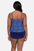 Woman turned away wearing a blue scroll printed tankini top with ruffles