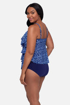 Woman turned left wearing a blue scroll printed tankini top with ruffles