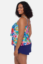 Woman turned left wearing a multicolored floral printed swim romper with ruffles