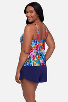 Woman turned left wearing a multicolored floral printed swim romper with ruffles