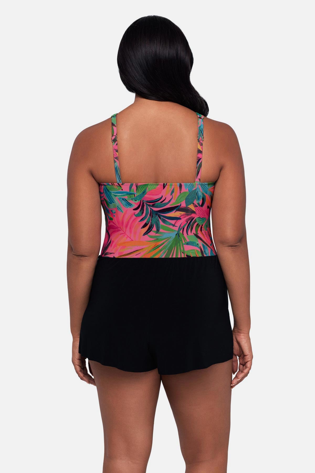 Woman turned away wearing a multicolored palm leaf printed swim romper