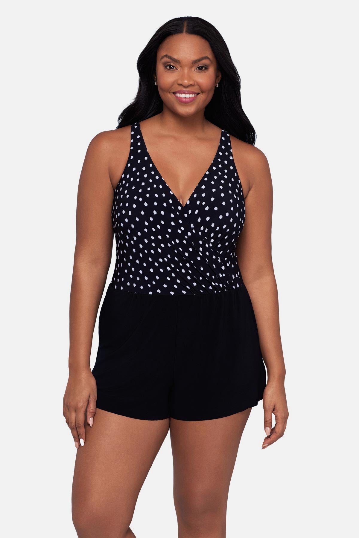 Woman wearing a black and white polka dot swim romper