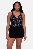 Woman wearing a black and white polka dot swim romper