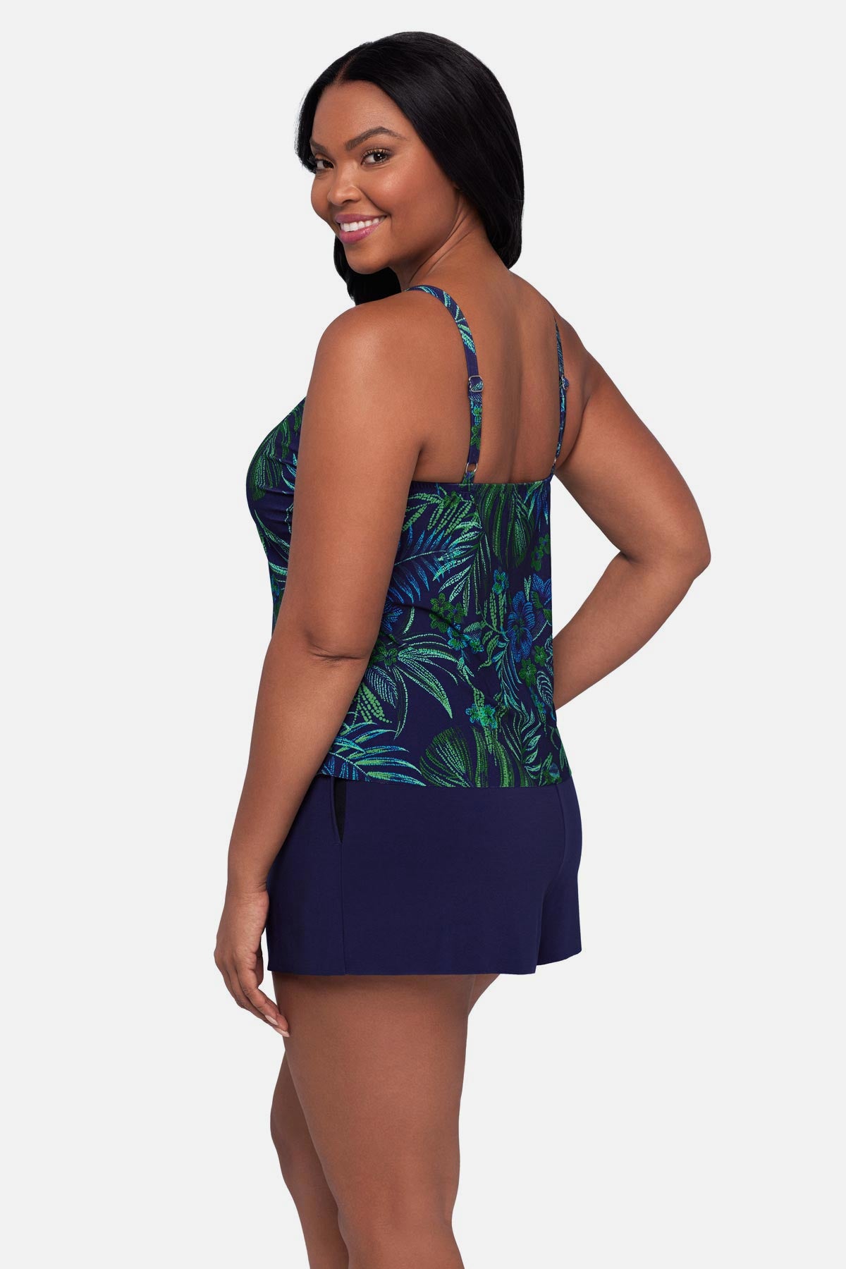 Woman turned left wearing a blue and green jungle printed swim romper