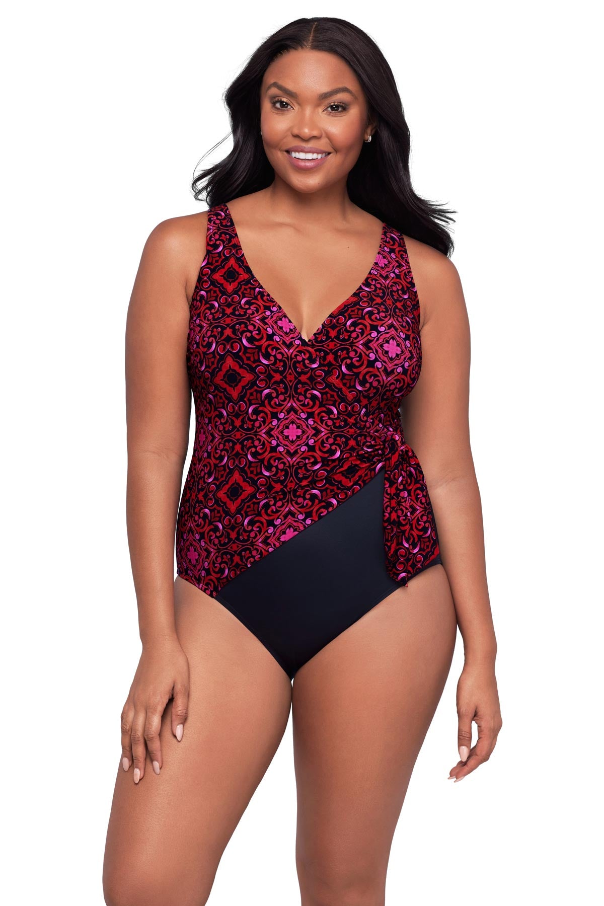 Woman wearing a red and pink tile print one-piece swimsuit