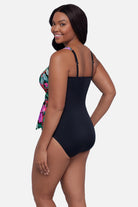 Woman turned to the left wearing floral and leaf printed multicolor one-piece swimsuit