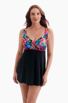 Woman wearing a swim dress with a multicolored print on the bust