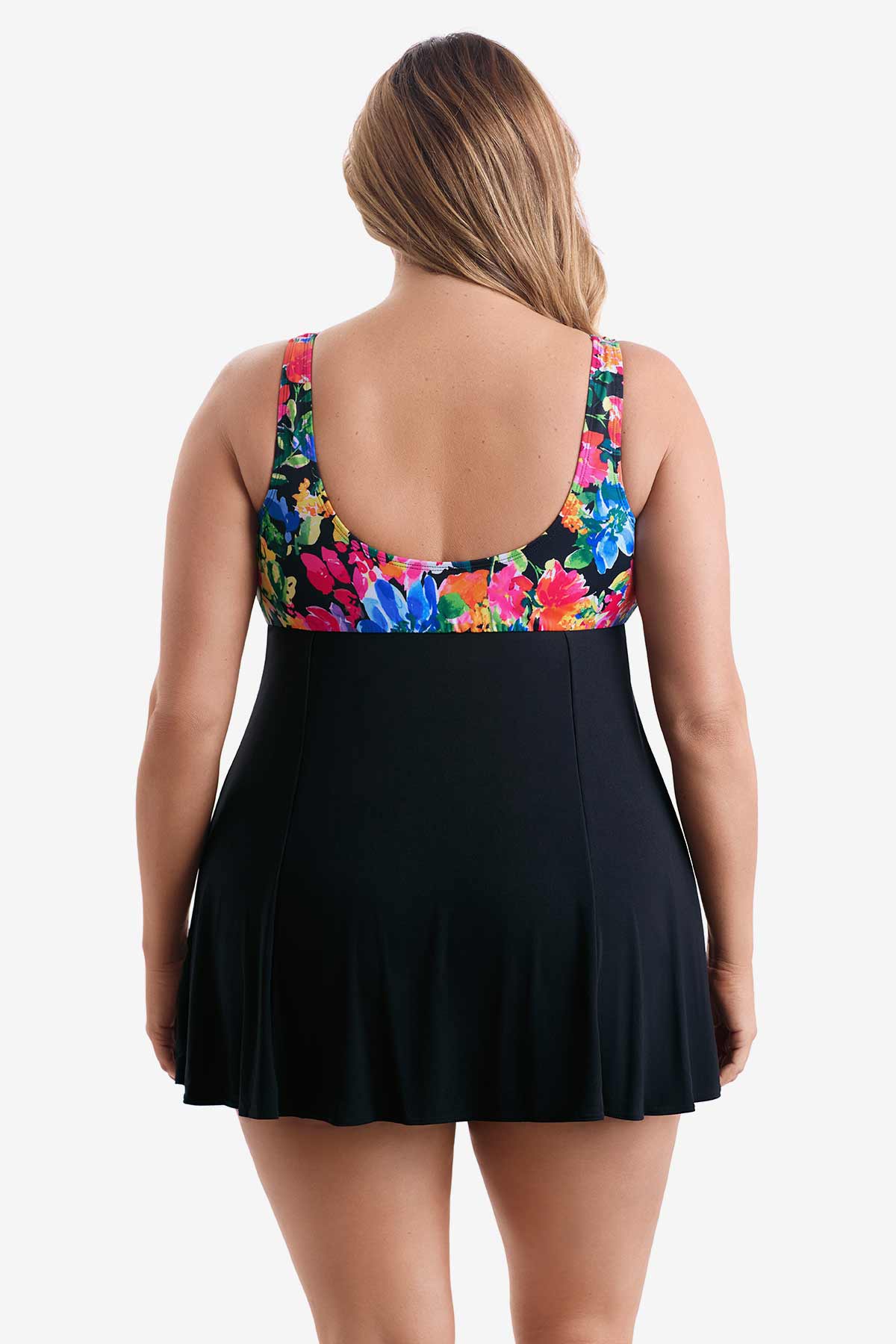 Woman turned away wearing a swim dress with a multicolored print on the bust