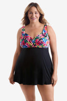 Woman wearing a swim dress with a multicolored print on the bust