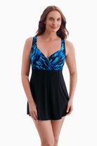 Woman wearing a swim dress with a black and blue print on the bust