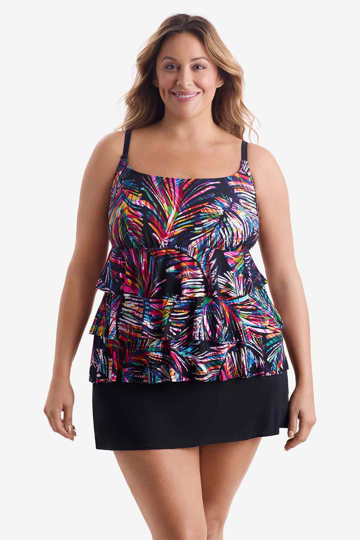 Woman wearing a tiered one-piece swimsuit with an abstract rainbow pattern