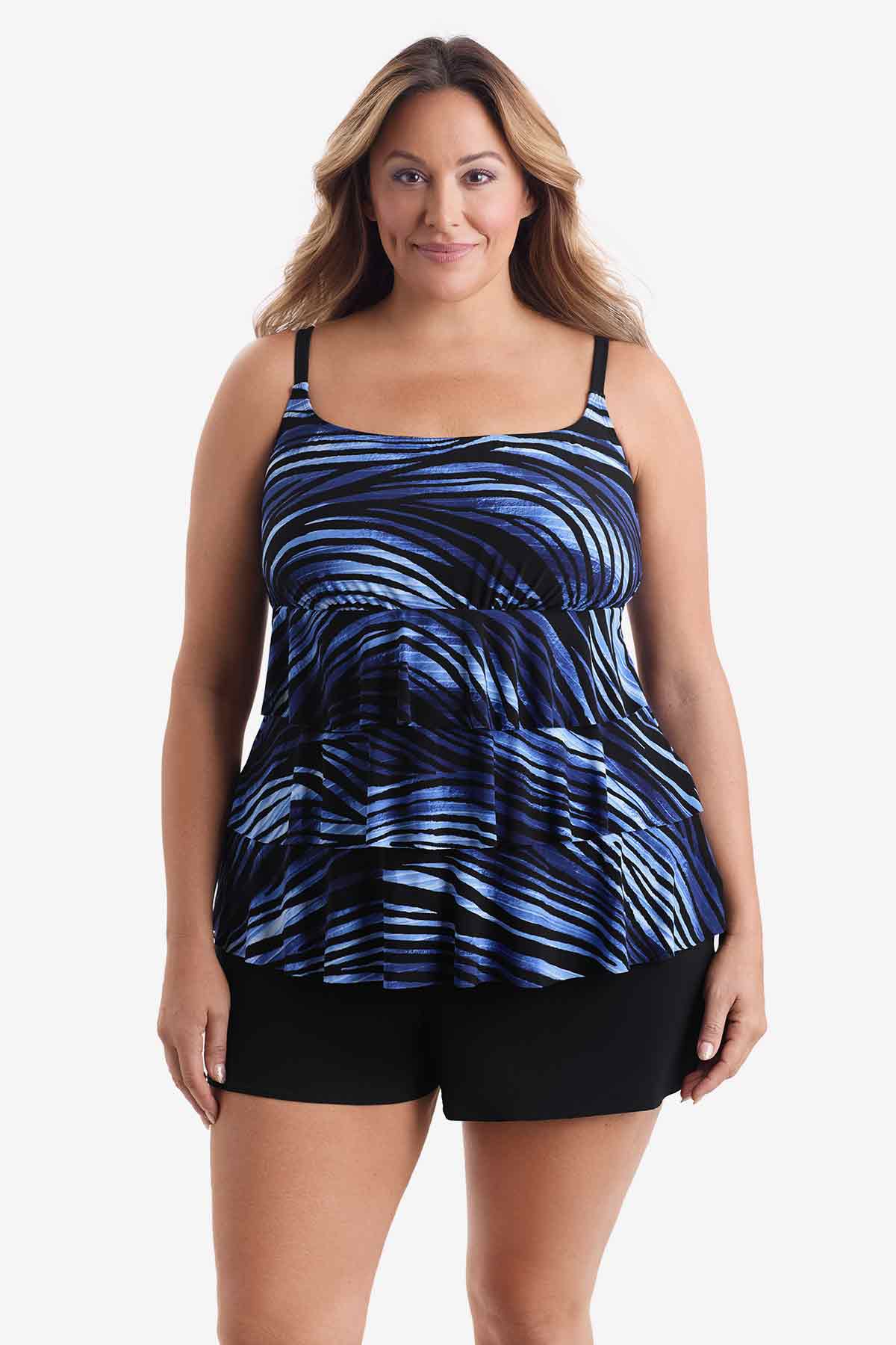 Woman wearing a tiered one-piece swimsuit with a black and blue pattern