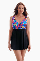 Woman wearing a swim dress with a multicolored pattern on the bust