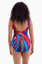 Woman faced away wearing a one-piece swimsuit with a multicolored radial pattern