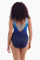 Woman faced away wearing a blue ombre one-piece swimsuit with an X back