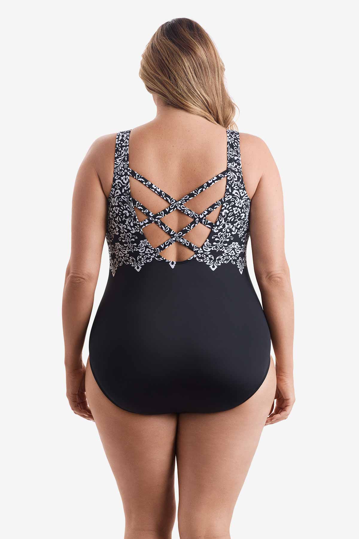 Woman faced away wearing a one-piece swimsuit with a black and white pattern on the X back detail