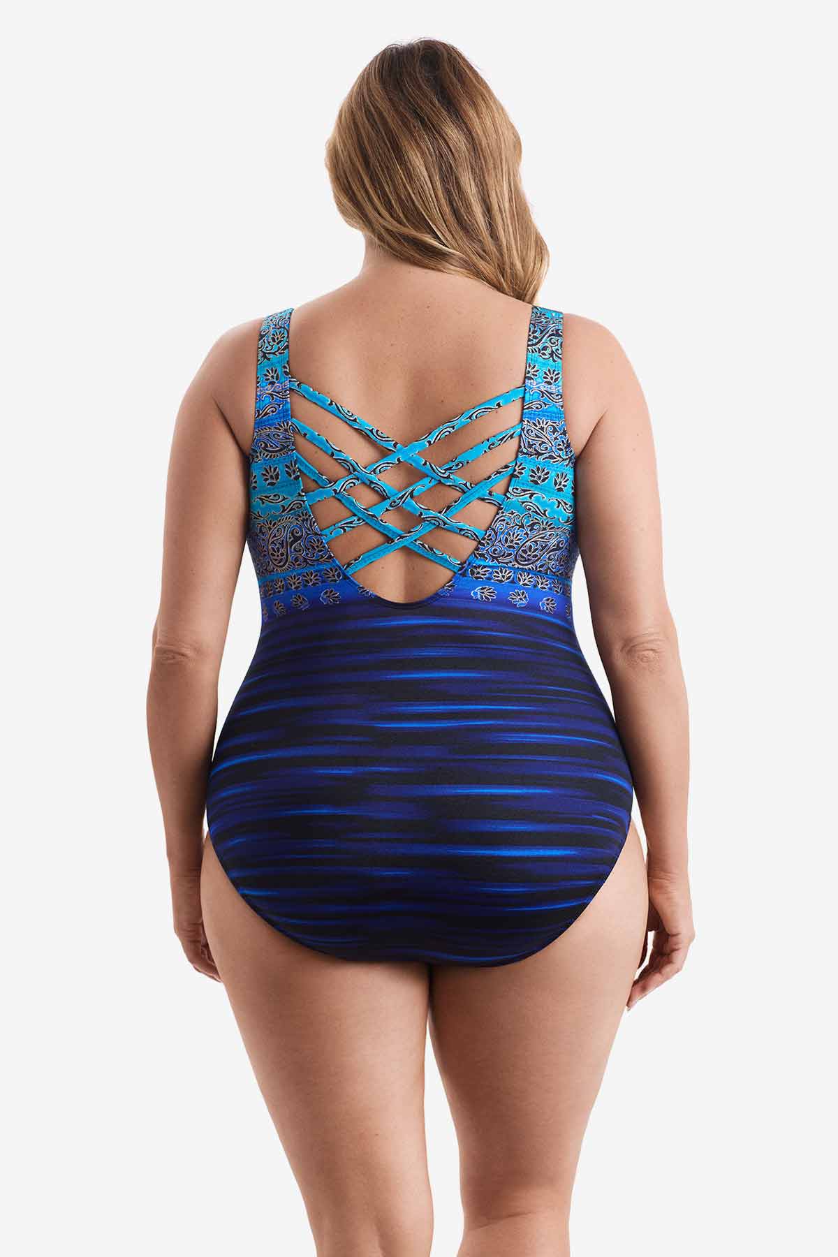 Woman turned away wearing a one-piece swimsuit with various blue patterns throughout suit