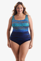 Woman wearing a one-piece swimsuit with various blue patterns throughout suit