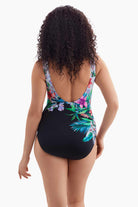 Woman turned away wearing a one-piece swimsuit with florals across the back